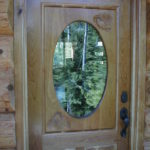 Custom cherry enrtry door with chickadees and pinecones carved in